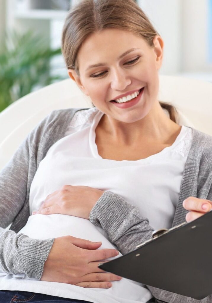 Pregnant Woman at Doctor looking at clipboard